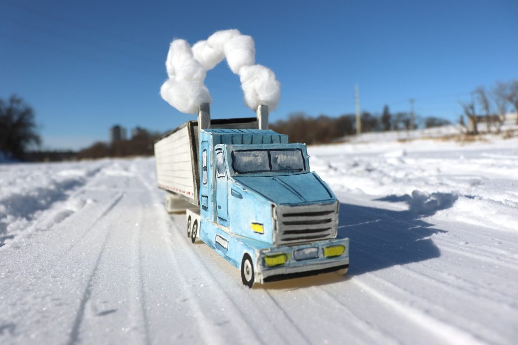 Paper model of a semi-truck navigating an ice road.